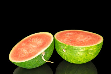 Two juicy watermelon halves, macro, isolated on black background.
