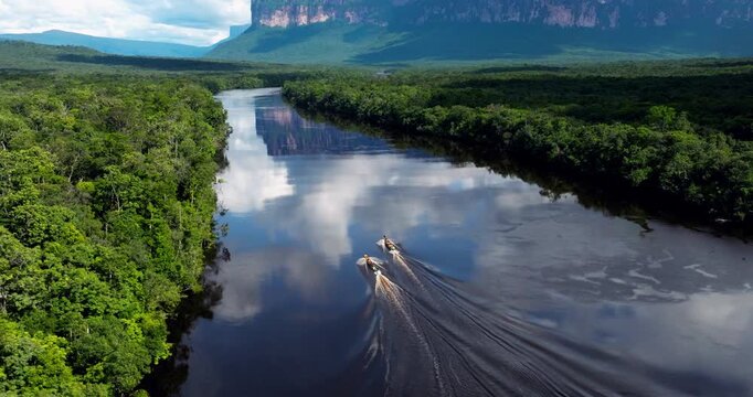 Motor Boats Across The Tranquil Churun River Towards Angel Falls In Canaima, Venezuela. Aerial Drone Shot