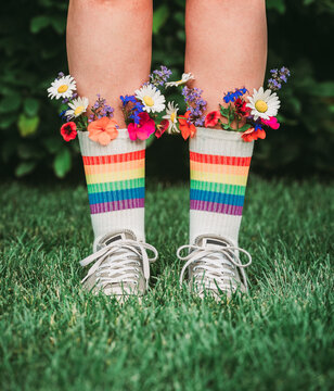Legs in rainbow socks with colorful flowers in the top for LGBTQ+
