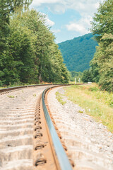 a railway track passing through mountains and forests
