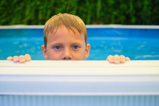 Boy peeking over edge of swimming pool