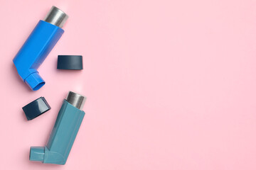 Asthma inhalers on pink background, top view. Space for text