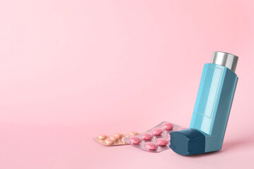 Inhaler and pills on pink background, closeup with space for text. Asthma treatment