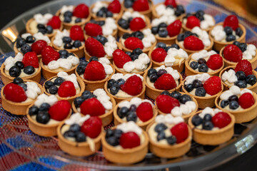 Fruit and berry tartlets dessert. Closeup of delicious pastry sweets. French bakery catering