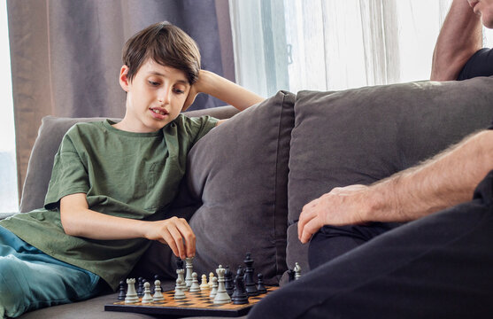 Father and son playing chess at home