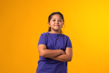 Smiling kid girl looking at camera over yellow background. Childhood and  positive emotions concept