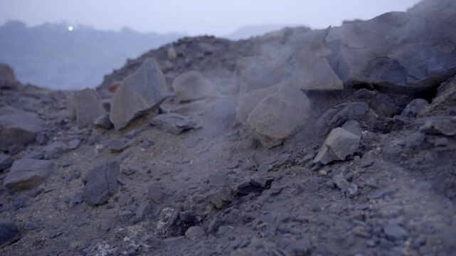 Coal mine with smoke and burning embers coming from the underground coal field fire, Jharia, Jharkhand