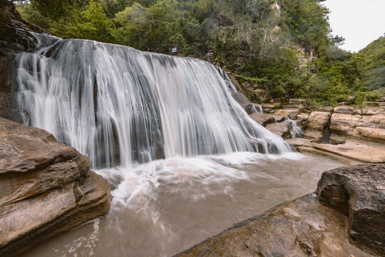 Waterfall splashing on rocky landscape at Air Terjun Tanggedu, Indonesia; Ndapayami, Kanatang, East Sumba Regency, East Nusa Tenggara, Indonesia