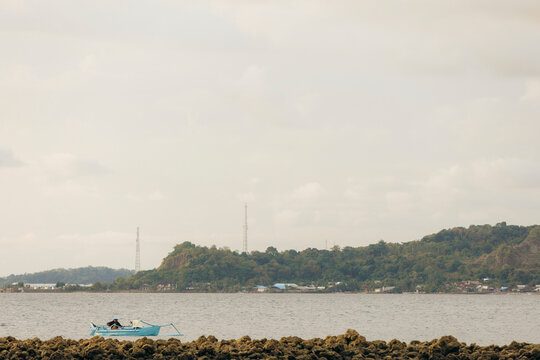 Fisherman fishing from his small bloat along the shoreline near Dutungan Island on the Makassar Strait in Indonesia; Dutungan Island, Cilellang, South Sulawesi, Indonesia