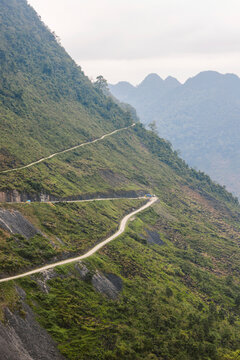 Road with hairpin turn winding along a mountainside in Ha Giang, Vietnam; Ha Giang, Vietnam