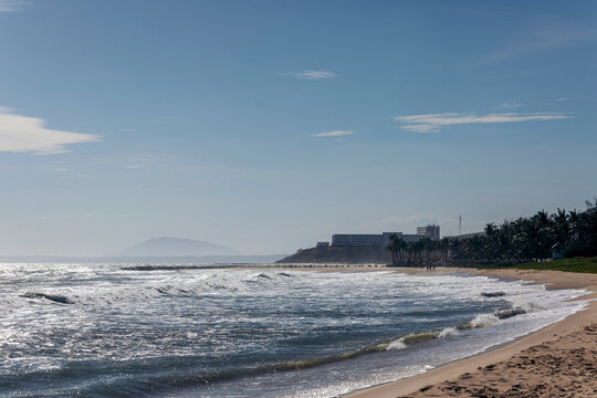 Surf rolling into the beach on a sunny day along the coast of Mui Ne, Vietnam; Bai bien Tu Lam, Mui Ne, Vietman