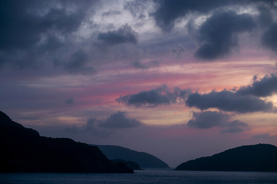 Beautiful soft light in the sky at twilight over silhouetted land and water in the Con Dao archipelago, Vietnam; Con Dao, Ba Rịa - Vung Tau, Vietnam