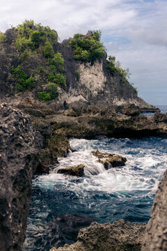 Surf flowing over rocks along the beautiful rugged coastline of Central Sulawesi, Indonesia; Tanjung Gundul Pasir Putih, Banggai Islands Regency, Central Sulawesi, Indonesia