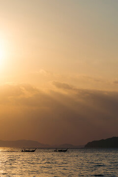 Warm sunset light over the ocean and rugged coastline at Ao Nang Beach, Krabi, Thailand; Krabi, Thailand