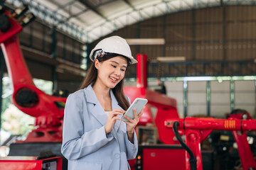 Engineers wearing a hard hat and a blue suit is holding a cell phone