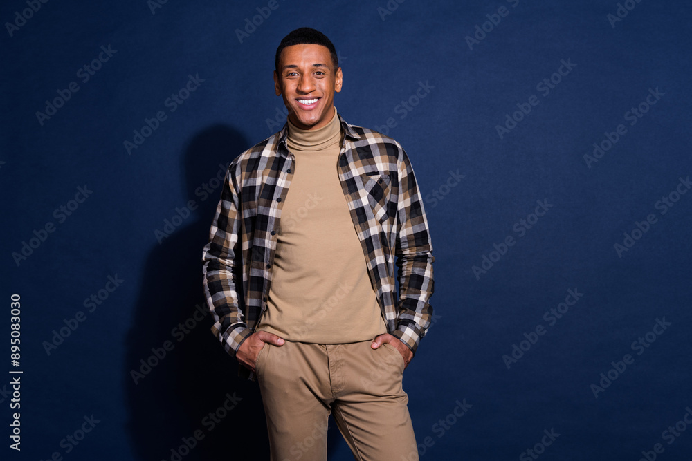 Wall mural Photo portrait of handsome young man hands pockets posing dressed stylish plaid garment isolated on dark blue color background