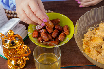 The hand of a Muslim woman at the festive table on the holiday of Kurban Bayram takes an inik