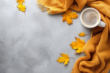 Cozy Autumn Concept with Warm Sweater, Coffee Cup, and Maple Leaves on Gray Background