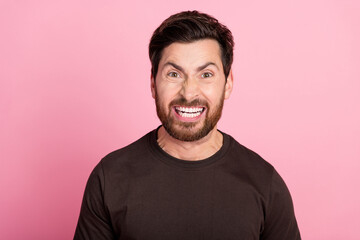 Fototapeta premium Photo of gloomy aggressive mad guy with stubble brunet hair dressed brown t-shirt screaming show teeth isolated on pink color background