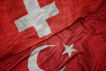 waving colorful flag of switzerland and national flag of turkey on the dollar money background....