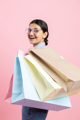 Brunette woman wearing glasses shirt and jeans holding shopping bags buying clothing in fashion...
