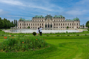 Obraz premium Wien, Österreich, das berühmte Schloss Belvedere, mit Schlosspark, Touristenmagnet - zwei asiatische Touristen fotografieren das Bauwerk