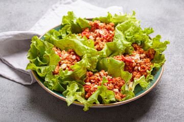 Lettuce wraps filled with a savory mixture of minced meat, herbs, and spices, creating a flavorful and refreshing appetizer or light healthy meal high in protein