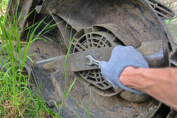 Obraz premium Replacing a lawn mower blade. electric lawn mower repair