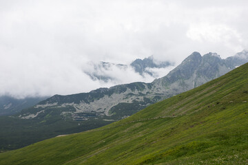 Obraz premium Mountain valley in the Tatras. Polish mountains. Landscape in the mountains. Clouds descend along the mountain gorge.