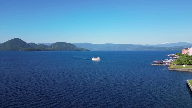 Lake Toya, Hokkaido, Japan: Aerial drone footage of the lake Toya with the tourist cruise ship linking the onsen to Nakajima island in Hokkaido in summer. 