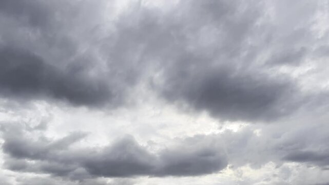 Moody Overcast Sky with Thick Dark Clouds Moving Slowly, Creating a Gloomy and Dramatic Atmosphere for Weather Forecasts or Nature Scenes. 4K Stock Footage