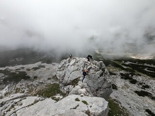  A climber on a Via Ferrata route in the Alps, navigating rocky terrains with safety gear, showcasing the adventure and stunning landscapes of alpine climbing