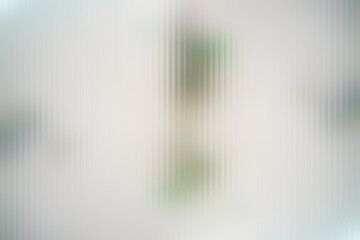Ribbed white glass texture. Ribbed fluted smeared blurred background. Vertical line stripes pastel polycarbonate panel. Glass blurred background. A Close up of corrugated glass texture vertical lines