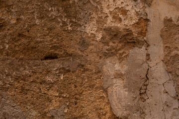 A weathered wall with cracks and peeling paint