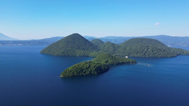 Lake Toya, Hokkaido, Japan: Aerial drone footage of the volcanic Nakajima island in the middle of lake Toya in Hokkaido in summer. 