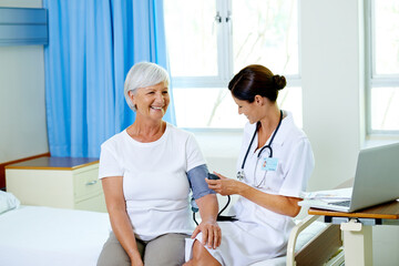 Nurse, senior and patient in hospital for blood pressure, routine check up and health management...