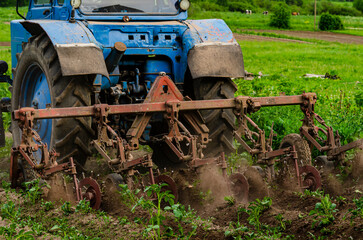 A tractor plows a field on a tractor. Compacts the soil, seals up weeds and improves the flow of...