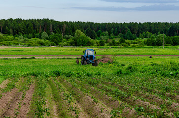 A tractor plows a field on a tractor. Compacts the soil, seals up weeds and improves the flow of...
