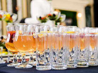 Fruit Punch Glasses on Table. Close-up of several glasses filled with refreshing fruit punch,...