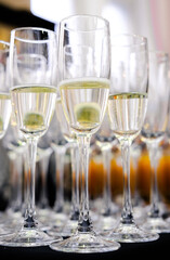 Vertical Close-Up of Champagne Flutes. Several champagne flutes filled with sparkling champagne, neatly arranged in rows, ready for a formal celebration. Vertical shot.