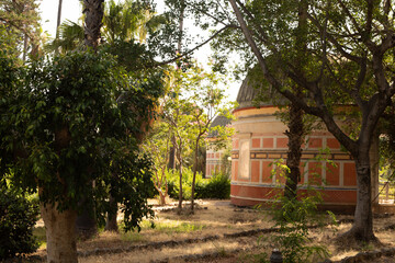 A picturesque garden with lush foliage surrounding a charming orange and white structure
