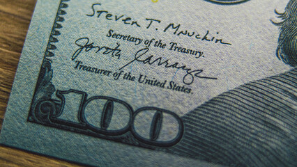 Process of examining authenticity of hundred dollar bill for currency exchange or payment. 100 US...