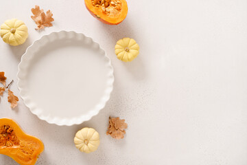Autumn pumpkins, fall leaves, empty baking dish. Concept cook Pumpkin pie on white background. Top view. Copy space. Thanksgiving Day.