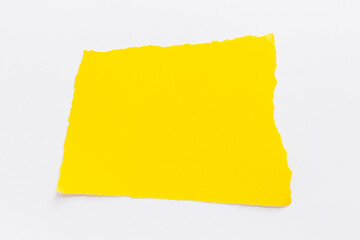 Yellow torn paper lies on a white background. Text note