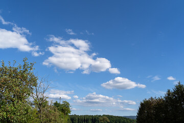 Blue sky with white clouds and trees