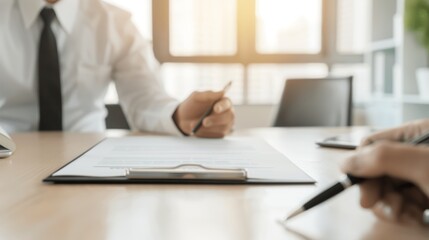 Close-up of business people discussing documents during a meeting at a modern office setting with sunlight illuminating the workspace.