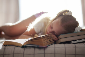 Little girl fell asleep reading books
