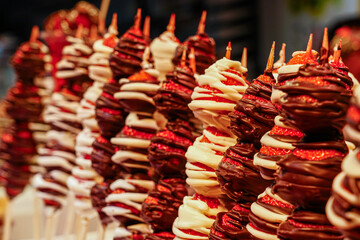 Chocolate coated fresh strawberry skewers at fruit stall at famous Barcelona food market La Boqueria