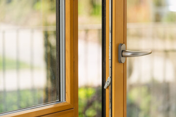 Modern wooden window or balcony door with silver handle