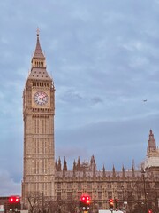 Obraz premium Big Ben towering over London with a cloudy sky backdrop. 
